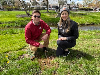 Man and Woman smiling in front of newly planted tree in Greenfield 